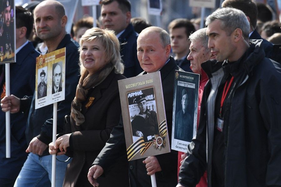 Russian President Vladimir Putin (centre) and other participants carry portraits of their relatives - WWII soldiers - as they take part in the Immortal Regiment march on Red Square in central Moscow on 9 May 2022.(Natalia Kolesnikova/AFP)