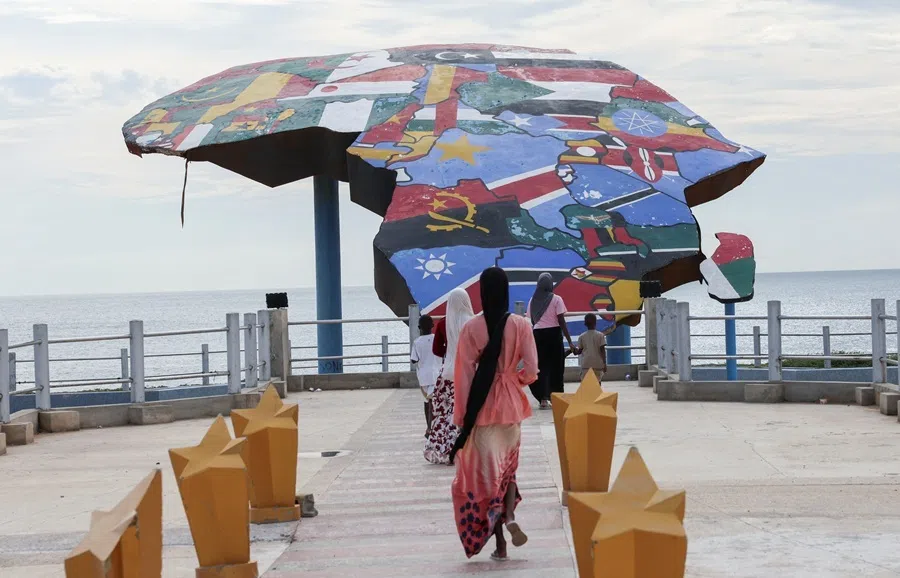 People walk towards a sculpture of the African continent, painted with the flags of African nations, at the Place du Souvenir Africain in Dakar, Senegal, 3 September 2026.