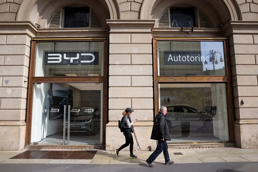 People walk in front of BYD Auto company and Autotorino store in Milan, Italy, on 20 March 2024. (Claudia Greco/Reuters)