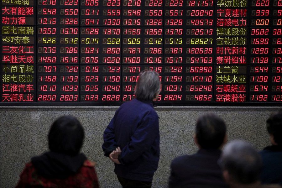 Investors look at an electronic board showing stock information at a brokerage house in Shanghai, China, on 7 March 2016. (Aly Song/Reuters)