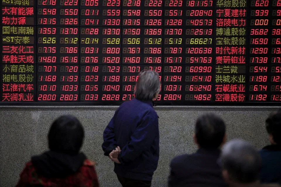 Investors look at an electronic board showing stock information at a brokerage house in Shanghai, China, on 7 March 2016. (Aly Song/Reuters)