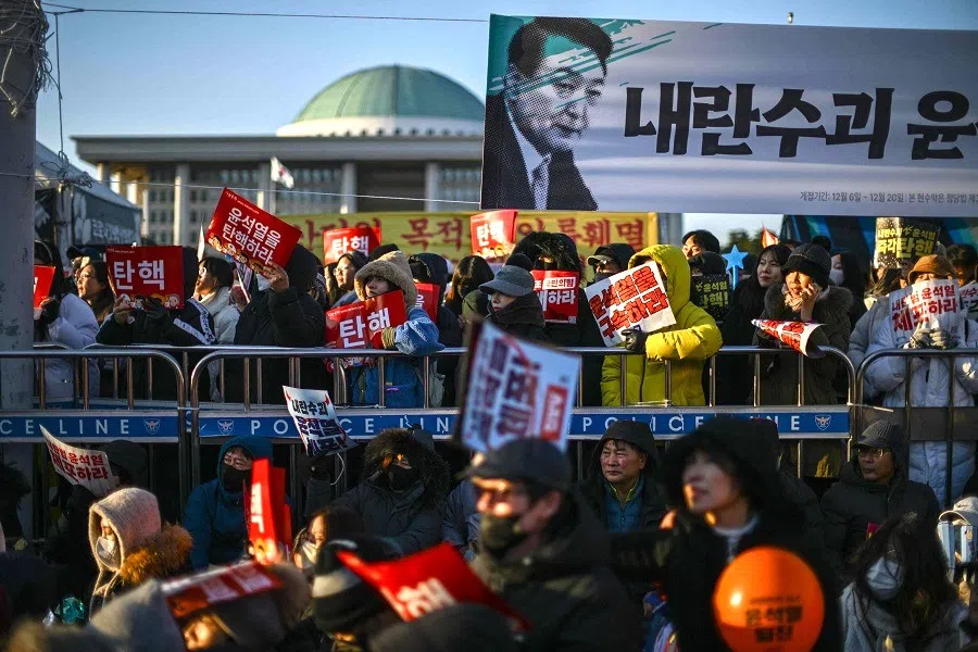 Protesters calling for the ouster of South Korean President Yoon Suk-yeol gather for the outcome of the second martial law impeachment vote outside the National Assembly in Seoul on 14 December 2024. (Anthony Wallace/AFP)