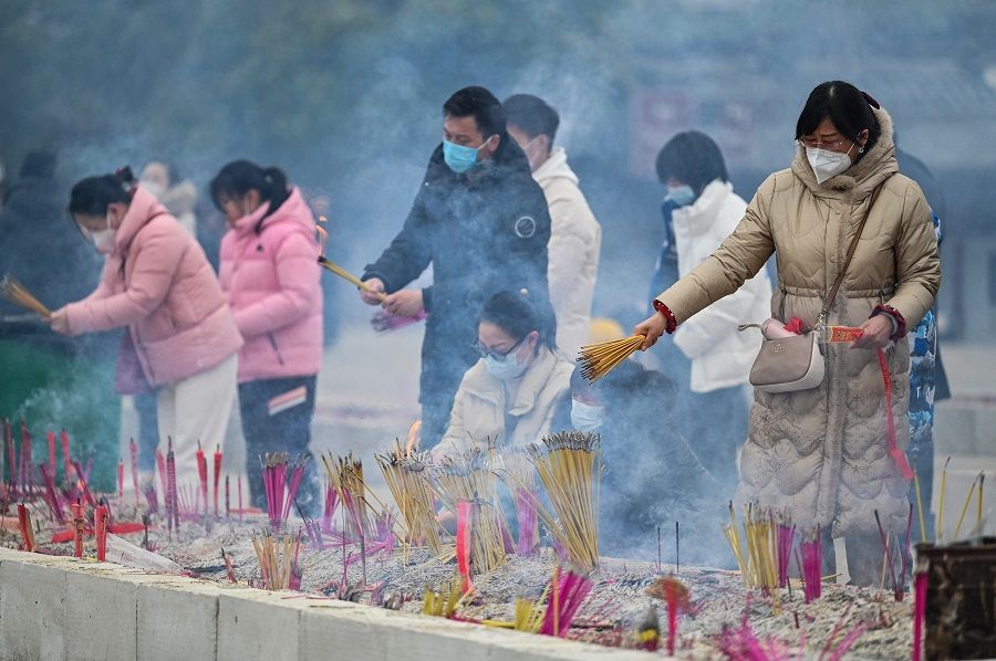 People burn incense sticks at the Guiyuan Buddhist temple in Wuhan, Hubei province, China, on 23 January 2023. (Hector Retamal/AFP)