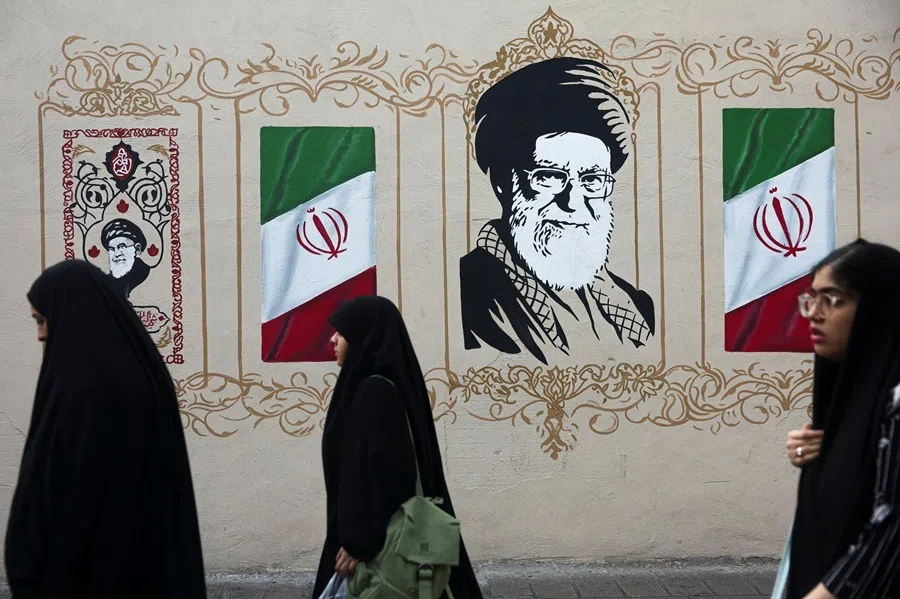 People walk by a mural depicting Iran's late Supreme Leader Ayatollah Ali Khamenei, on a street in Tehran, Iran, on 13 August 2026.