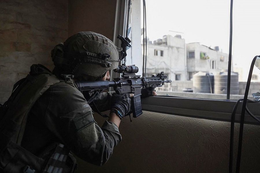 This handout picture released by the Israeli army on 18 December 2023 shows a soldier taking position during operations in the Gaza Strip, amid continuing battles between Israel and Hamas. (Israeli Army/Handout/AFP)