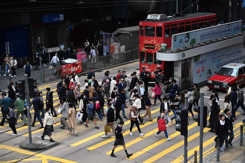 People cross an intersection in the central business district of Hong Kong on 27 February 2024. (Peter Parks/AFP)