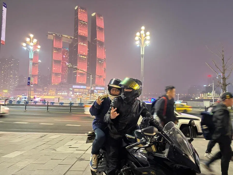 A tourist poses for a photo for a motorcycle photoshoot on Nanbin Road in Chongqing, January 2026. (Liu Liu/SPH Media)
