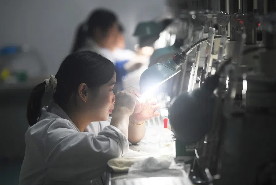 A worker checks parts at a factory which produces medical endoscope lenses in Hangzhou, Zhejiang province, China, on 31 October 2024. (AFP)
