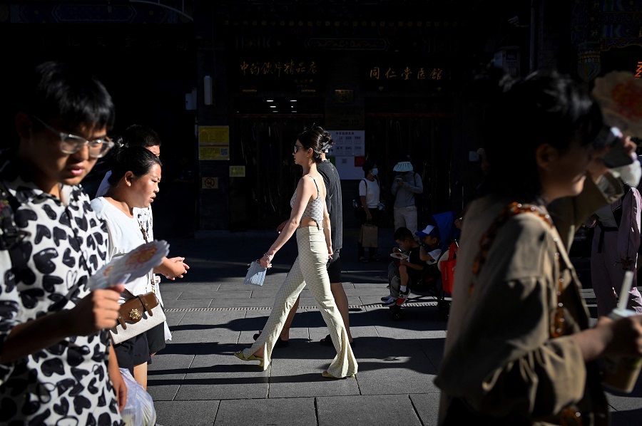 People visit a business street in Beijing on 22 August 2023. (Wang Zhao/AFP)