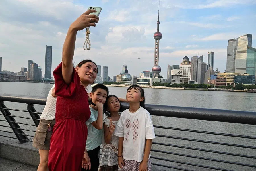 People visit the Bund promenade along the Huangpu river in Shanghai on 17 July 2026.