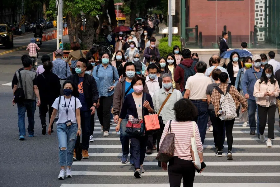 This photo taken on 31 March 2021 shows people crossing a street in Taipei. (Sam Yeh/AFP)