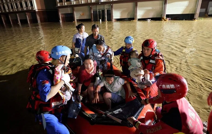Rescue workers evacuate residents in a rubber dinghy after floodwaters inundate villages downstream of the Liulan Reservoir dam breach, following heavy rainfall brought by typhoon Maysak, at a village in Hengzhou, Guangxi Zhuang Autonomous Region, China, 6 July 2026.