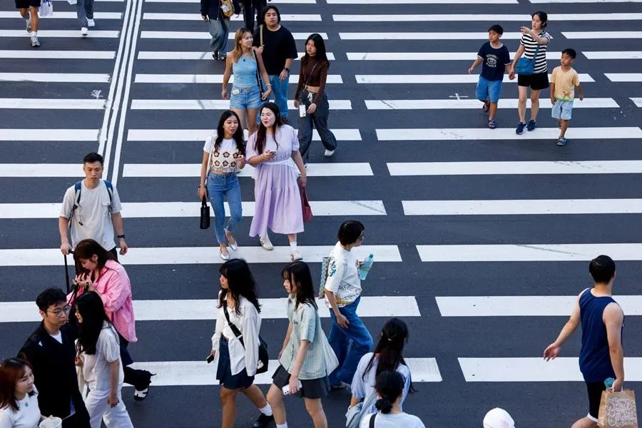People cross the road at a shopping district in Taipei, Taiwan, 8 November 2025. (Ann Wang/Reuters)