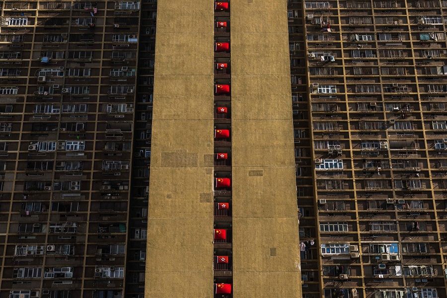 This picture taken in Hong Kong on 27 June 2022 shows a public housing estate decorated with China and Hong Kong flags ahead of the 25th anniversary of the city's handover from Britain to China which falls on 1 July. (Dale de la Rey/AFP)