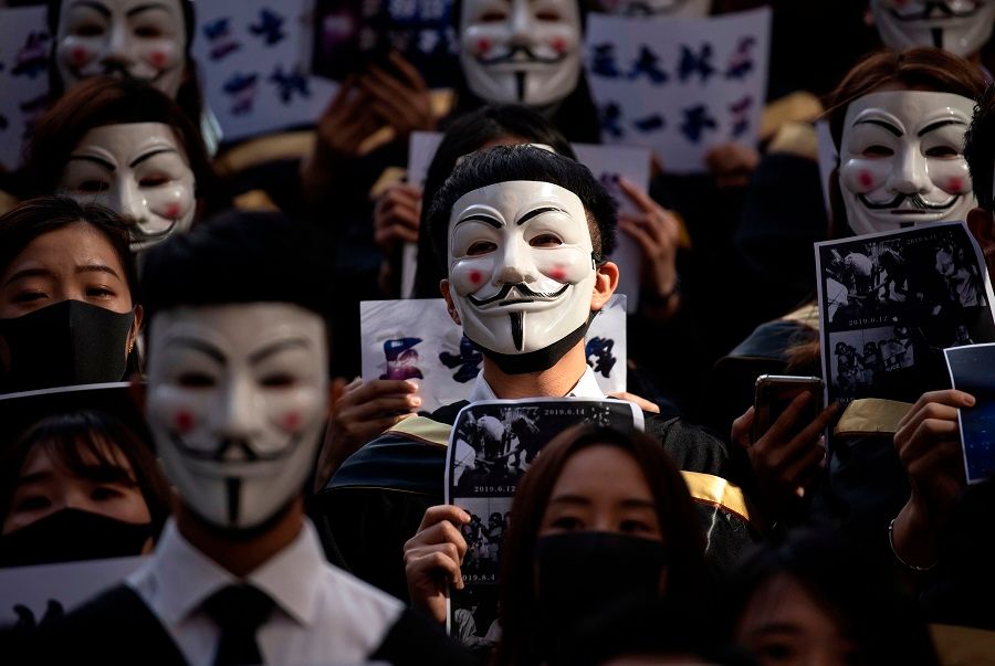 University students clad in Guy Fawkes at the Hong Kong Polytechnic University in the face of Hong Kong's face mask ban (Noel Celis / AFP)