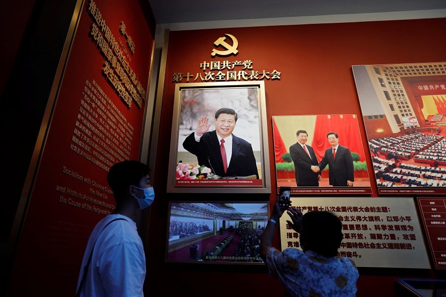 A visitor takes pictures in front of an image of Chinese President Xi Jinping at the Museum of the Communist Party of China in Beijing, China, 3 September 2022. (Florence Lo/Reuters)