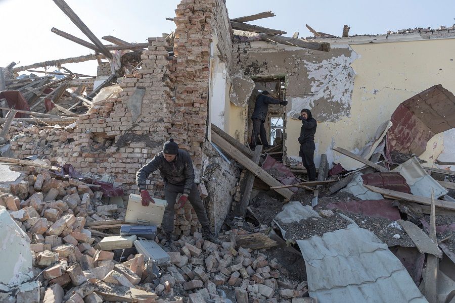 Locals clean up debris from the cultural centre destroyed in shelling earlier this month, as Russia's invasion of Ukraine continues, in the village of Byshiv outside Kyiv, Ukraine, 24 March 2022. (Marko Djurica/Reuters)