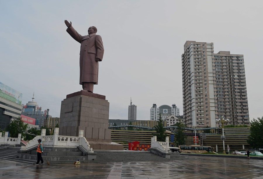 A worker stands in front of Mao Zedong sculpture at Dandong station at the border city of Dandong, in China's northeast Liaoning province on 11 August 2021. (Noel Celis/AFP)