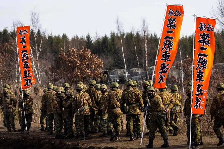 Members of Japan Ground Self-Defense Force Northern Army leave after a Type-90 tank live firing competition at the Hokkaido Great Maneuvering Ground in Eniwa, Hokkaido prefecture, Japan, on 7 December 2021. (Behrouz Mehri/AFP)