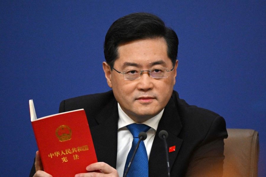 China's Foreign Minister Qin Gang holds a copy of China's constitution during a press conference at the Media Center of the National People's Congress (NPC) in Beijing on 7 March 2023. (Noel Celis/AFP)
