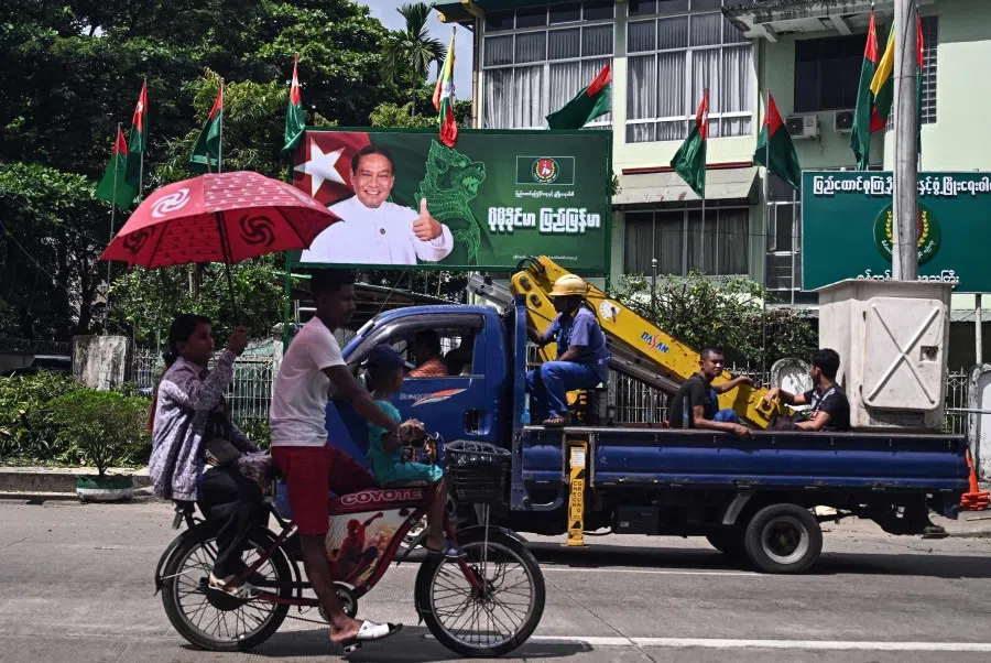 People drive past an election campaign billboard of Myanmar’s chairman of the army-backed ruling Union Solidarity and Development Party (USDP) Khin Yi ahead of the start of the election campaign in Yangon on 27 October 2025.