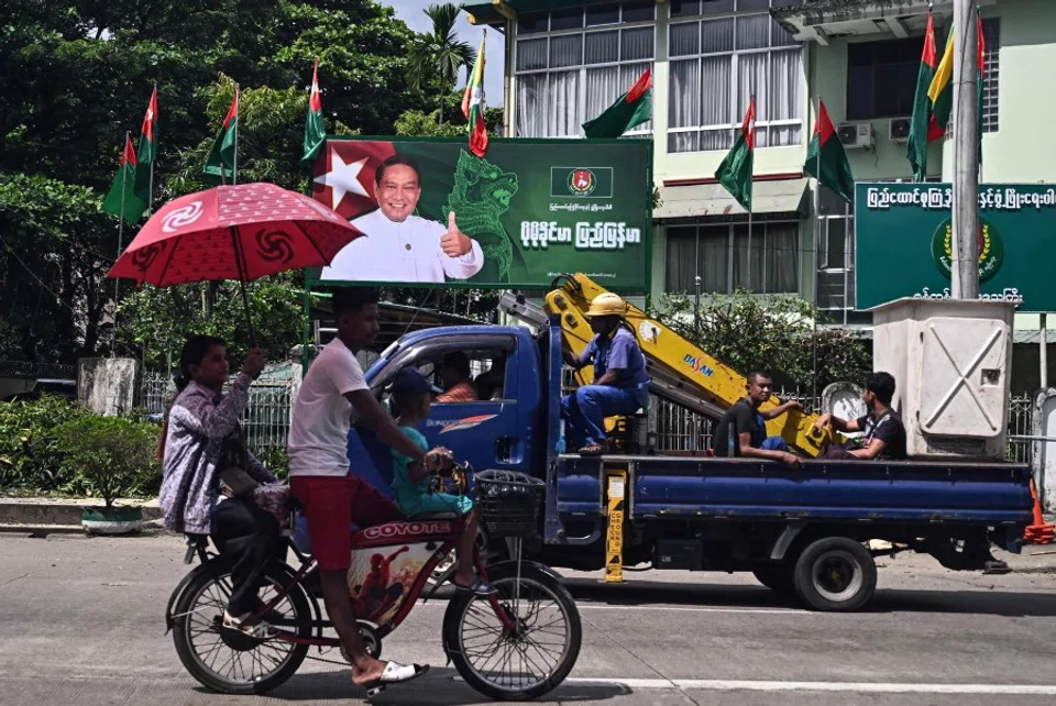 People drive past an election campaign billboard of Myanmar’s chairman of the army-backed ruling Union Solidarity and Development Party (USDP) Khin Yi ahead of the start of the election campaign in Yangon on 27 October 2025. (AFP)