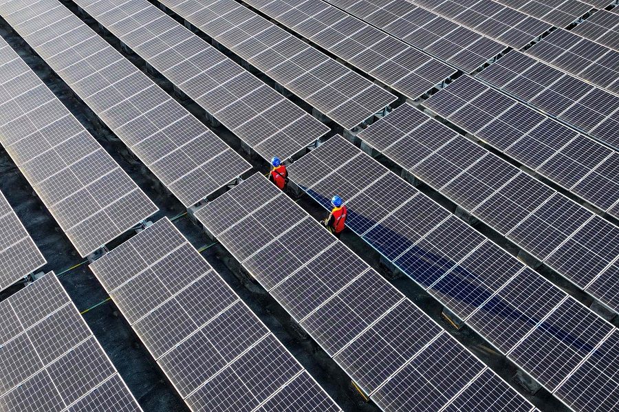 This photo taken on 21 February 2024 shows workers inspecting solar panels at a rooftop of a power plant in Fuzhou, Fujian province, China.  (AFP)