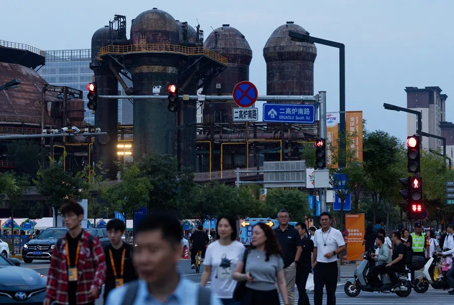 People cross a street in Beijing, China, 11 September 2025. (Maxim Shemetov/Reuters)
