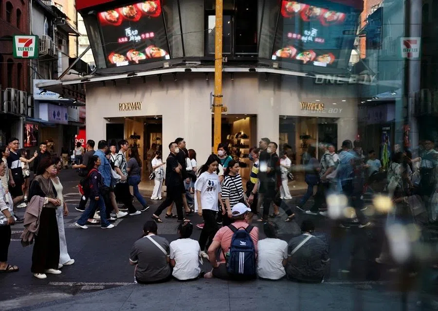 People walk in the shopping district of Ximending in Taipei, Taiwan, on 19 April 2026.