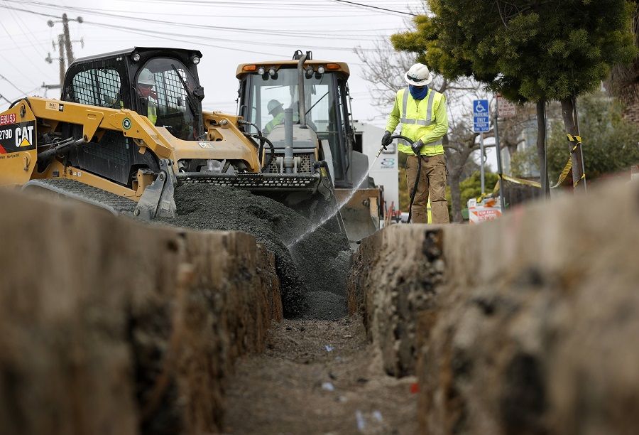 Workers with East Bay Municipal Utility District (EBMUD) fill a trench after installing new water pipe on 22 April 2021 in Oakland, California, US. (Justin Sullivan/Getty Images/AFP)