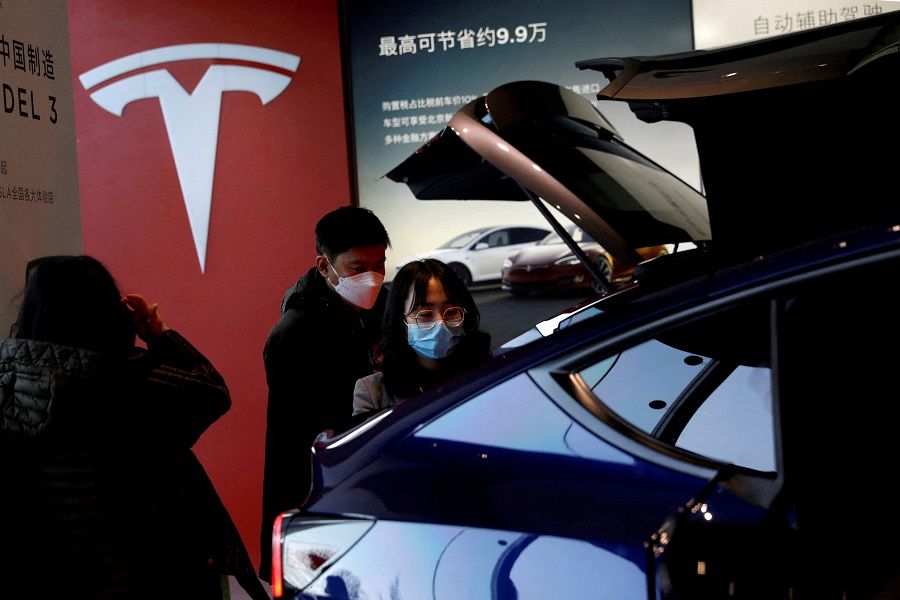 Visitors wearing face masks check a China-made Tesla Model Y sport utility vehicle (SUV) at the electric vehicle maker's showroom in Beijing, China, 5 January 2021. (Tingshu Wang/File Photo/Reuters)