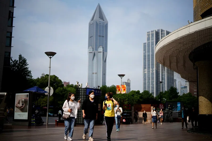 People wearing face masks walk on a street in Shanghai, China, 1 June 2022. (Aly Song/Reuters)