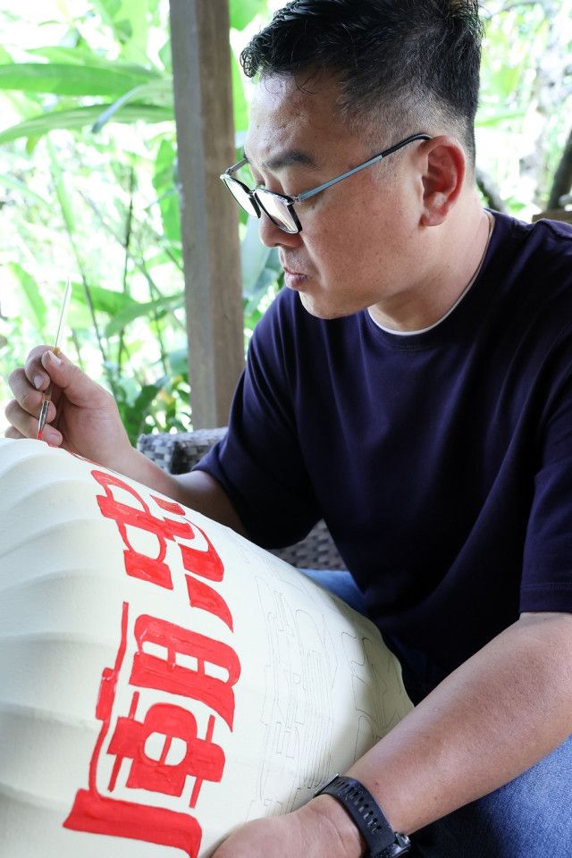 Andy Yeo painting a lantern at his studio.