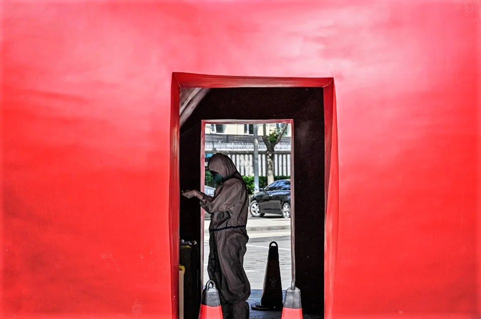 A health worker wearing personal protective equipment (PPE) is seen at a makeshift testing site outside a museum along a street in Beijing, China, on 4 May 2022. (Jade Gao/AFP)