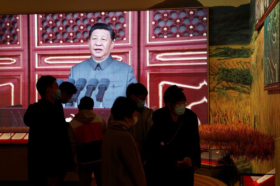 Visitors stand near exhibits of rice paddy fields and a screen showing an image of Chinese President Xi Jinping at the Museum of the Communist Party of China in Beijing, China, 11 November 2021. (Carlos Garcia Rawlins/Reuters)