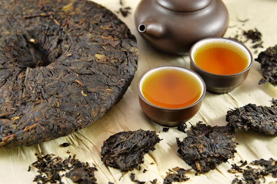 A pu-erh cake and cups of pu-erh tea. (iStock)