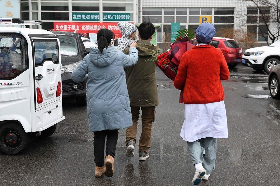 A nurse (right) accompanies a one-year-old boy and his parents as they leave after their recovery from the Covid-19 coronavirus, at the Youan Hospital in Beijing on 14 February 2020. (Greg Baker/AFP)