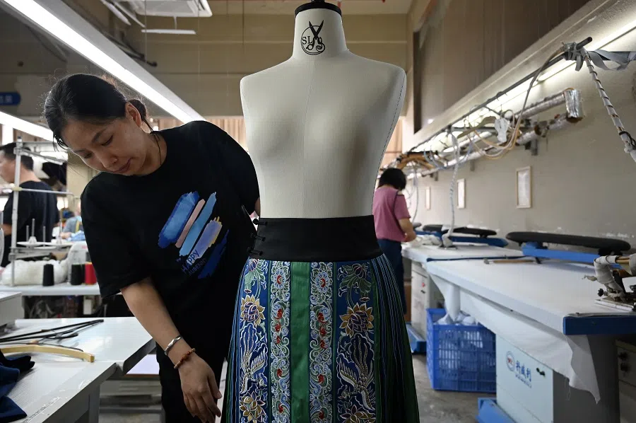 An employee checks a finished horse-face skirt, in Haizhu, Guangzhou, Guangdong province, China, on 7 May 2024. (CNS)