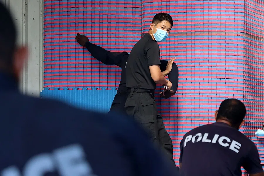 An undated handout photo released on 29 March 2022 by the Royal Solomon Islands Police Force (RSIPF) shows a China Police Liason Team officer (centre) training local RSIPF officers. (Handout/RSIPF/AFP)