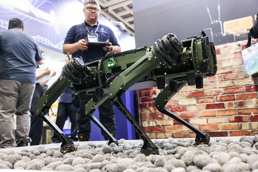 A staff member demonstrates a robotic dog produced by US company Ghost Robotics during the Taipei Aerospace & Defense Technology Exhibition in Taipei on 18 July 2025. (I-Hwa Cheng/AFP)