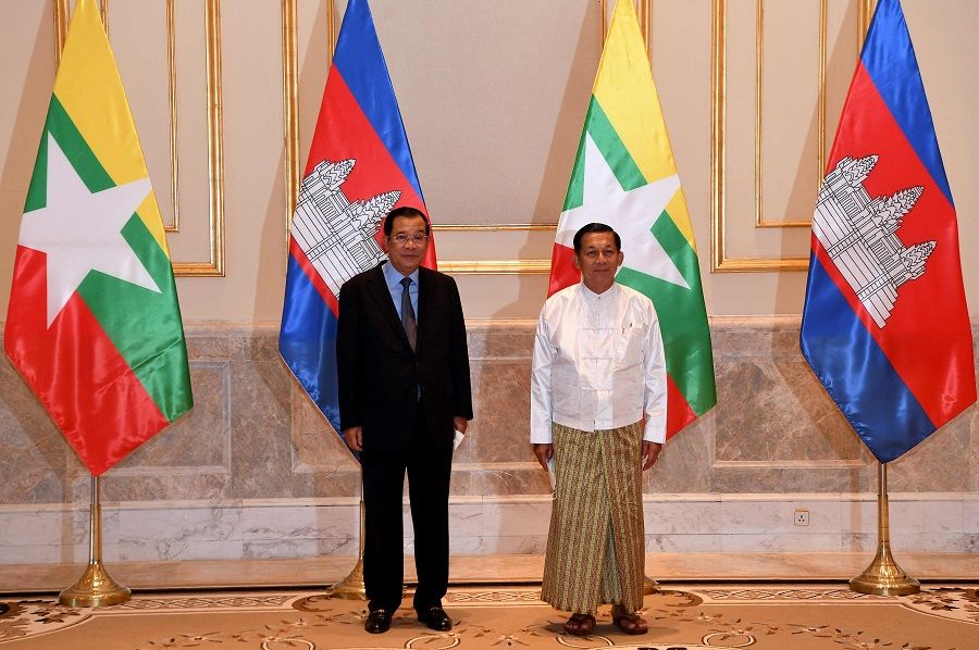 This handout photo taken and released by National Television of Cambodia (TVK) on 7 January 2022 shows Cambodia's Prime Minister Hun Sen (left) and Myanmar military chief Min Aung Hlaing posing for photos in Naypyidaw, Myanmar. (An Khoun SamAun/National Television of Cambodia (TVK)/AFP)