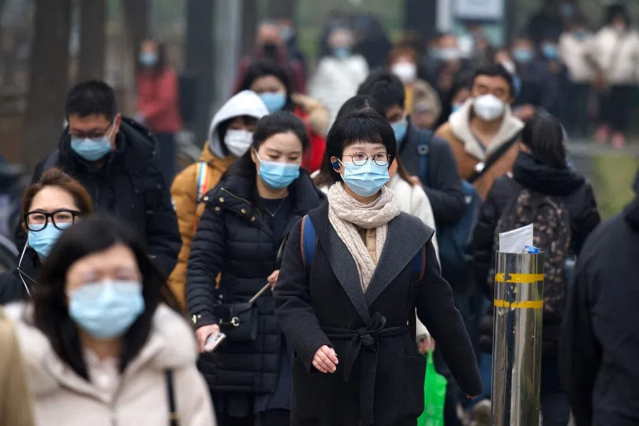 People walk along a street in Beijing on 5 March 2021. (Noel Celis/AFP)