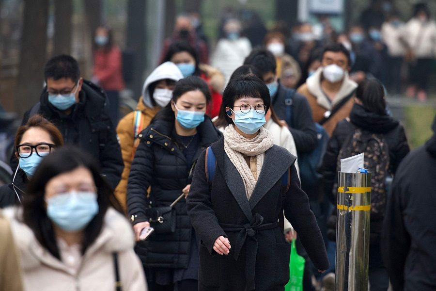 People walk along a street in Beijing on 5 March 2021. (Noel Celis/AFP)