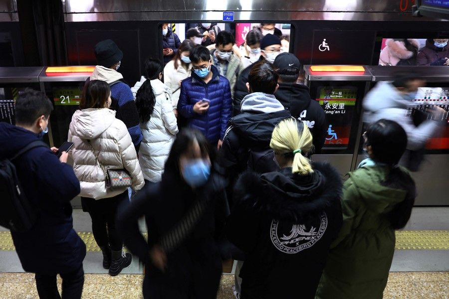 People get off a subway train during morning rush hour in Beijing, China, 17 January 2022. (Tingshu Wang/Reuters)