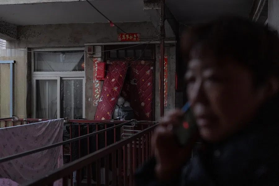 A neighbour calls for a ride-hailing driver as Sister Chen prepares to go home to Sichuan for Chinese New Year.