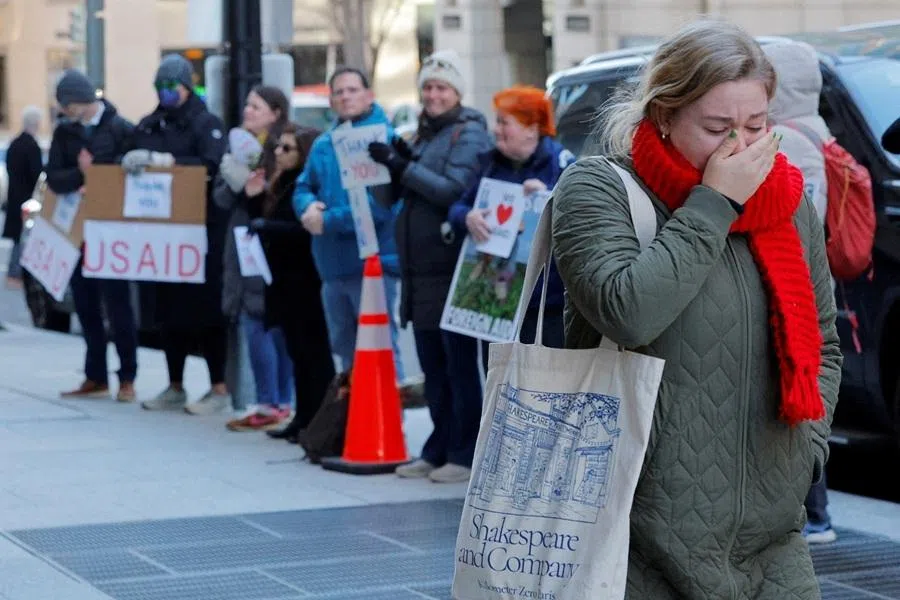 A recently fired US Agency for International Development (USAID) staff member reacts while leaving work, during a sendoff by former USAID staffers and supporters outside USAID offices in Washington, DC, US, on 21 February 2025.