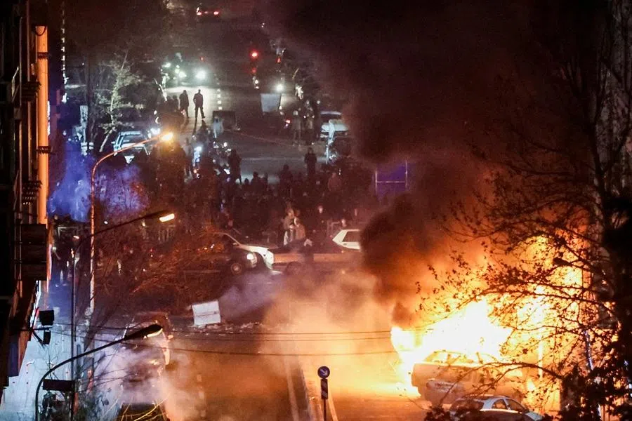 Cars burn in a street during a protest over the collapse of the currency's value, in Tehran, Iran, on 8 January 2026. (Stringer/West Asia News Agency via Reuters)