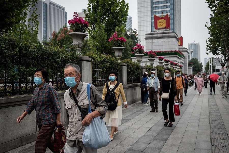 People walk along a street in Wuhan, Hubei, China, on 29 September 2020. (STR/AFP)