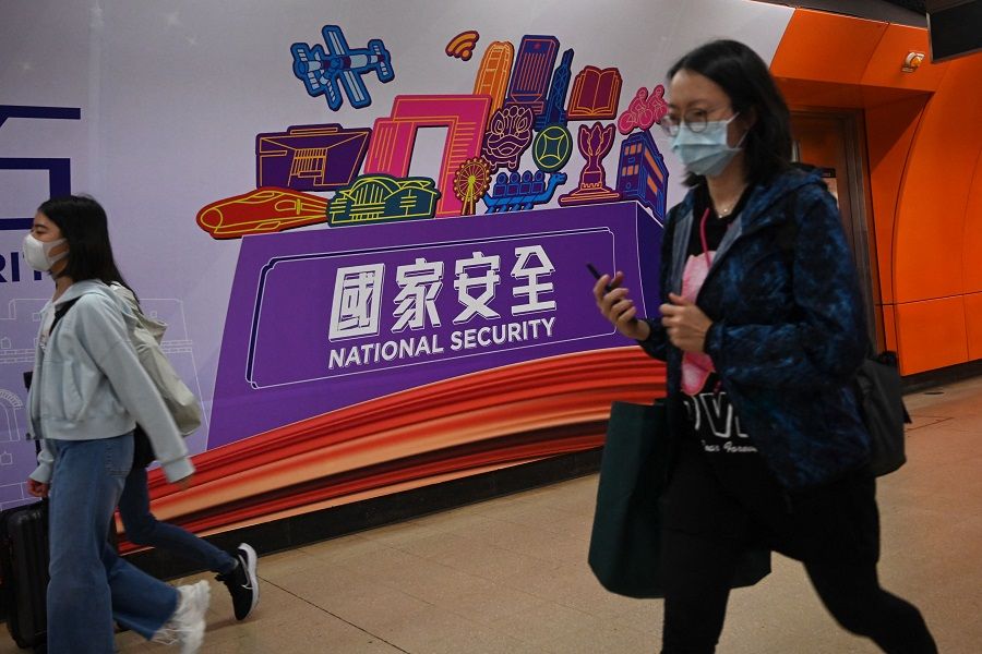 People walk past a national security banner at a train station in Hong Kong, China, on 15 April 2023. (Peter Parks/AFP)