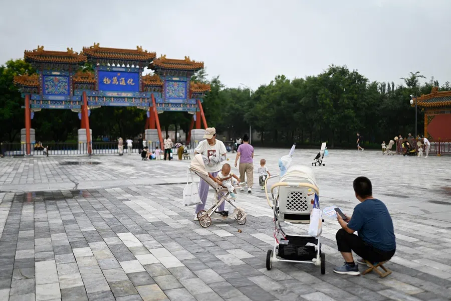 Local residents rest outside a temple near a residential area in Beijing on 21 August 2025. (Wang Zhao/AFP)